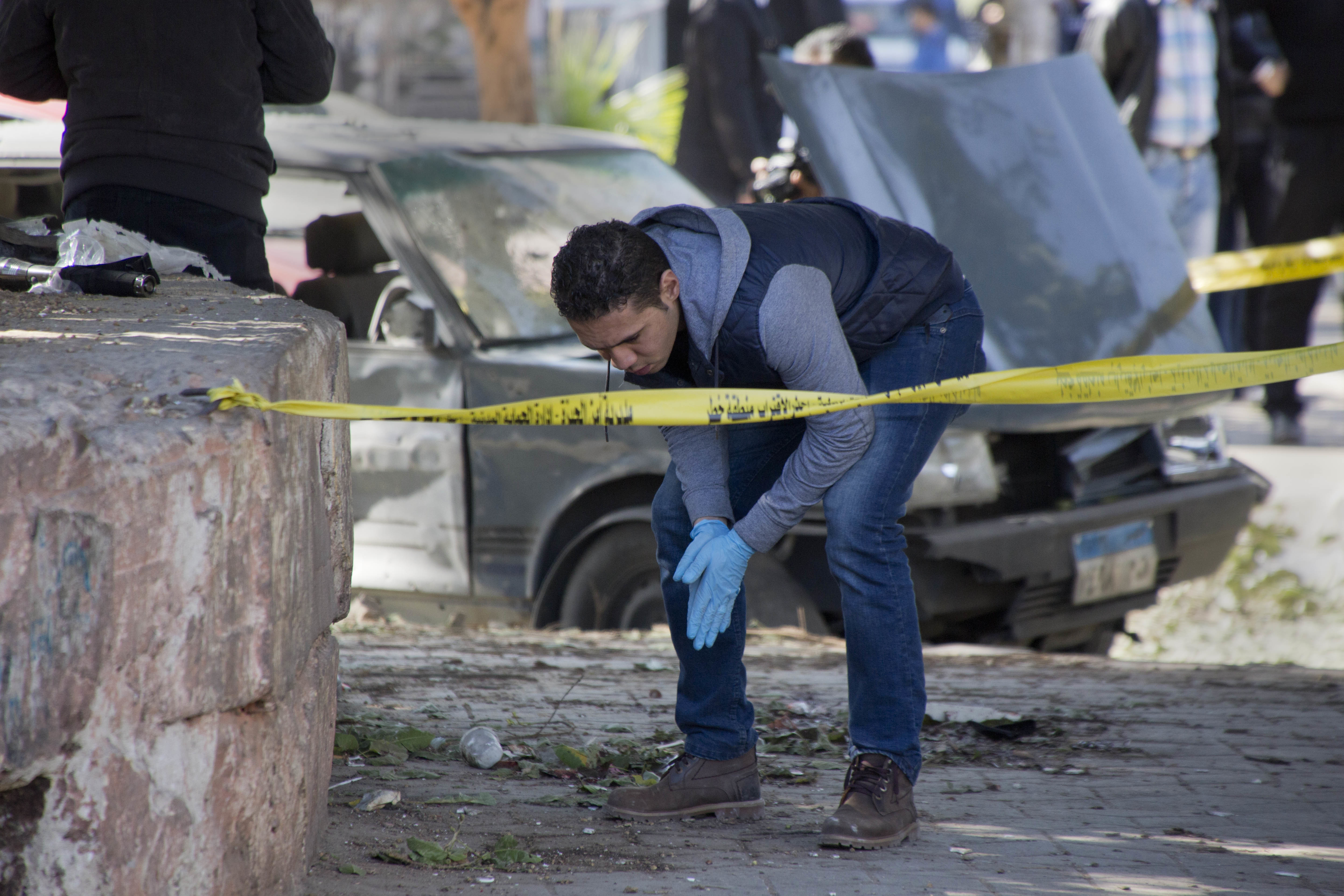 An Egyptian explosives expert looks for evidence at the site of a bomb explosion in Cairo, Egypt, on Dec. 9, 2016. (AP Photo/Amr Nabil)