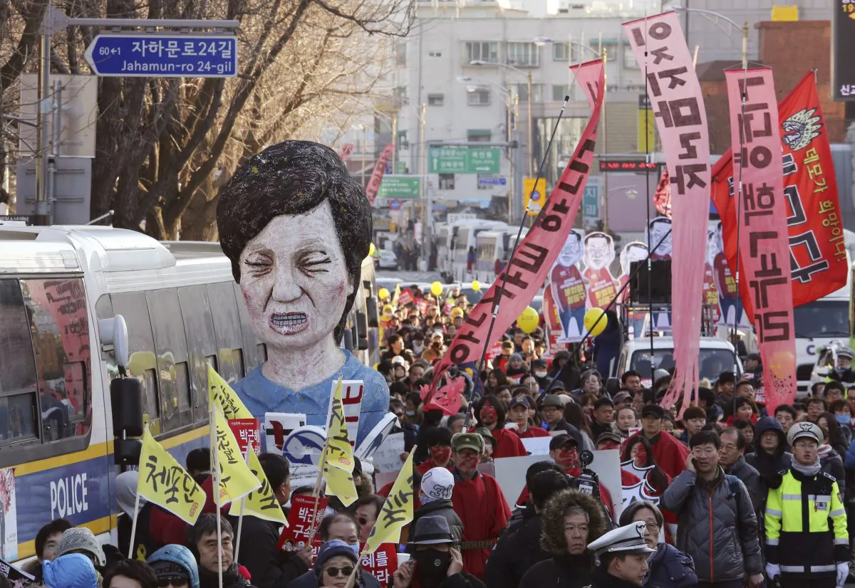 Protesters carry an effigy of impeached South Korean President Park Geun-hye as they march toward the presidential house during a rally in Seoul, on Dec. 10, 2016. The sign read "Impeach Park Geun-hye immediately." (AP Photo/Ahn Young-joon)