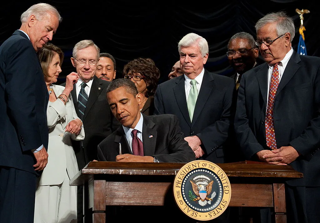 US President Barack Obama signs the Dodd-Frank Wall Street Reform and Consumer Protection Act alongside members of Congress, the administration and US Vice President Joe Biden(L) at the Ronald Reagan Building in Washington, DC, July 21, 2010. The Trump administration may repeal the Act, which has come under fire for slowing down the economic recovery. (SAUL LOEB/AFP/Getty Images)