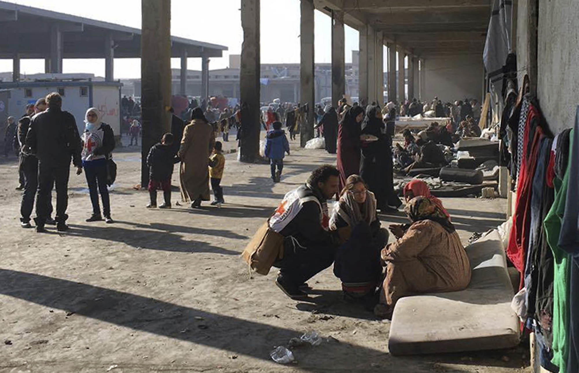 Syrians who were displaced with their families from eastern Aleppo gather at the collective shelter, in the village of Jibreen south of Aleppo, Syria on Dec. 12, 2016. (ICRC via AP)