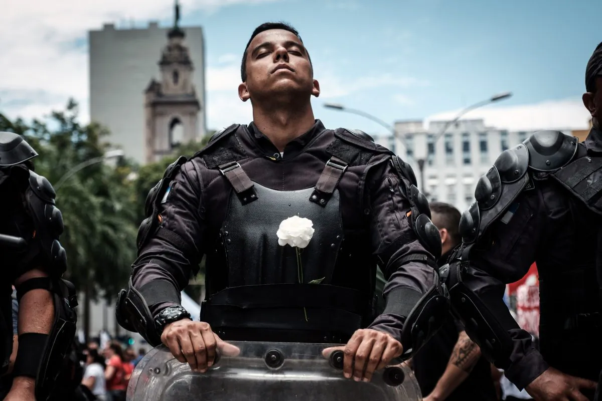 A riot police officer bearing a white flower on his bulletproof vest in Rio de Janeiro, Brazil, on Dec. 12, 2018. (Yasuyoshi Chiba/AFP/Getty Images)