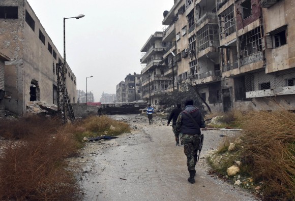 This photo released by the Syrian official news agency SANA, shows Syrian troops and pro-government gunmen marching through the streets of east Aleppo, Syria, on Dec. 13, 2016. (SANA via AP)