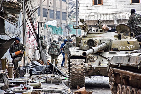 Syrian pro-government forces patrol the northern city of Aleppo on Dec. 14, 2016. Shelling and air strikes sent terrified residents running through the streets of Aleppo as a deal to evacuate rebel districts of the city was in danger of falling apart. (GEORGE OURFALIAN/AFP/Getty Images)