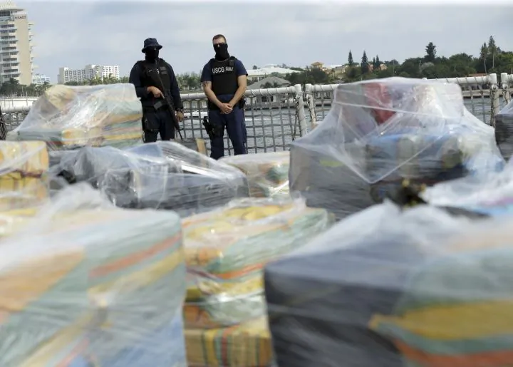 Coast Guardsmen stand over pallets containing more than 26 tons of cocaine worth at least $715 million on the flight deck of of 418-foot Coast Guard Cutter Hamilton, Thursday, Dec. 15, 2016, in Fort Lauderdale, Fla. (AP Photo/Lynne Sladky)