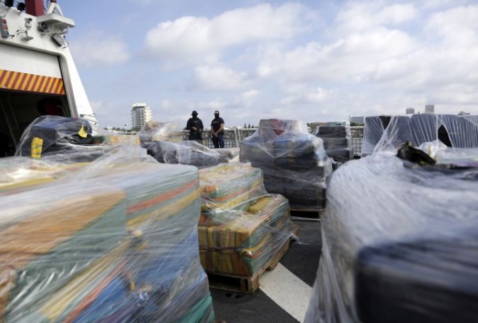 Coast Guardsmen stand over pallets containing more than 26 tons of cocaine worth at least $715 million on the flight deck of of 418-foot Coast Guard Cutter Hamilton, Thursday, Dec. 15, 2016, in Fort Lauderdale, Fla. The cocaine was brought ashore Thursday following multiple recent seizures by the U.S. Coast Guard and the Royal Canadian Navy in the eastern Pacific. (AP Photo/Lynne Sladky)