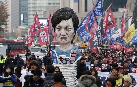 In this file photo, members of the Korean Confederation of Trade Unions carry an effigy of South Korean President Park Geun-hye as they march during a rally calling for Park to step down in Seoul, South Korea. (AP Photo/Lee Jin-man, File)