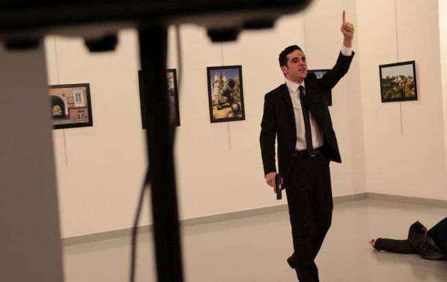 A man gestures near to Andrei Karlov on ground, the Russian Ambassador to Turkey at a photo gallery in Ankara, Turkey, Monday, Dec. 19, 2016. An Associated Press photographer says a gunman has fired shots at the Russian ambassador to Turkey. The ambassador's condition wasn't immediately known. (AP Photo/Burhan Ozbilici)