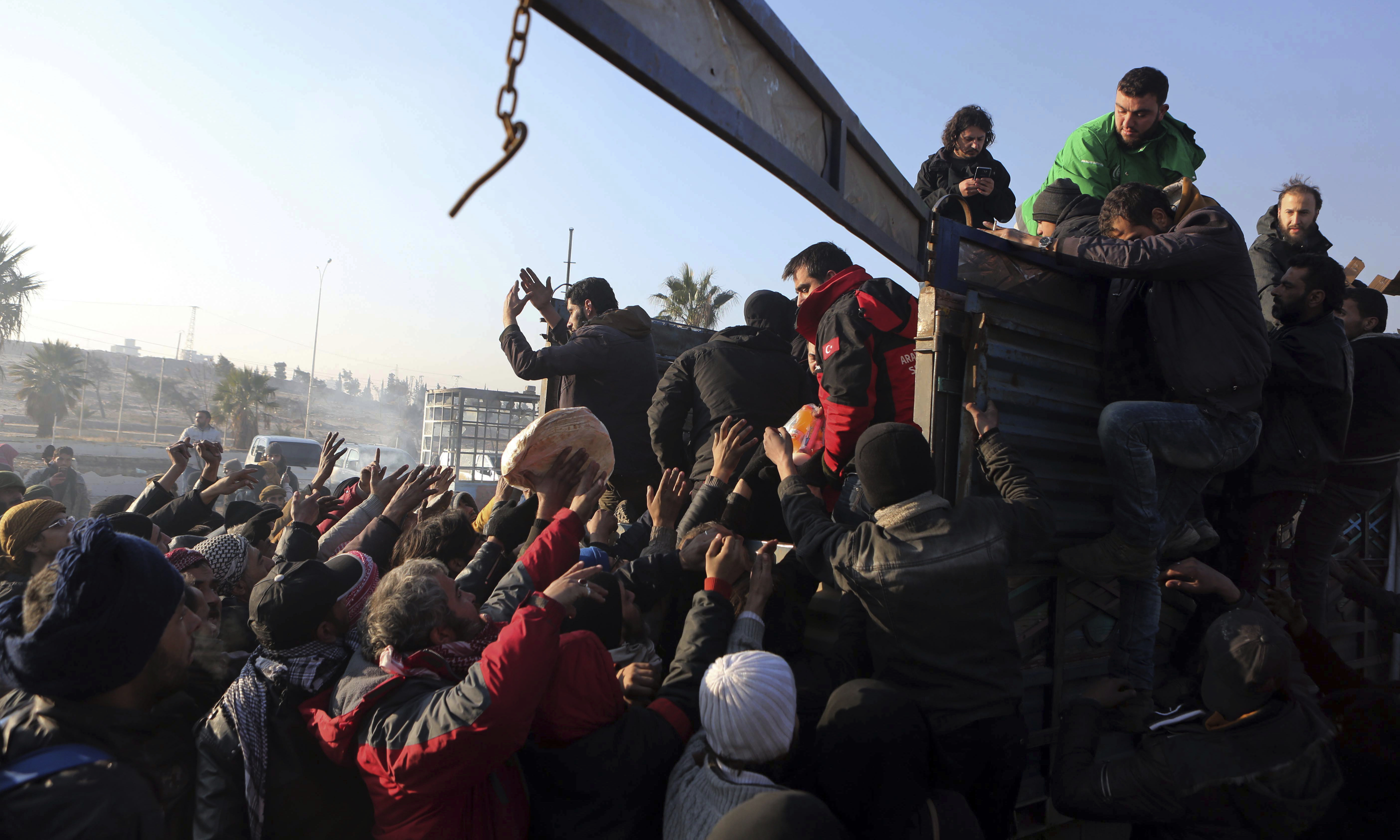 Syrians evacuated from the embattled Syrian city of Aleppo during the ceasefire get free bread after their arrival at a refugee camp in Rashidin, near Idlib, Syria on Dec. 19, 2016. (AP Photo)