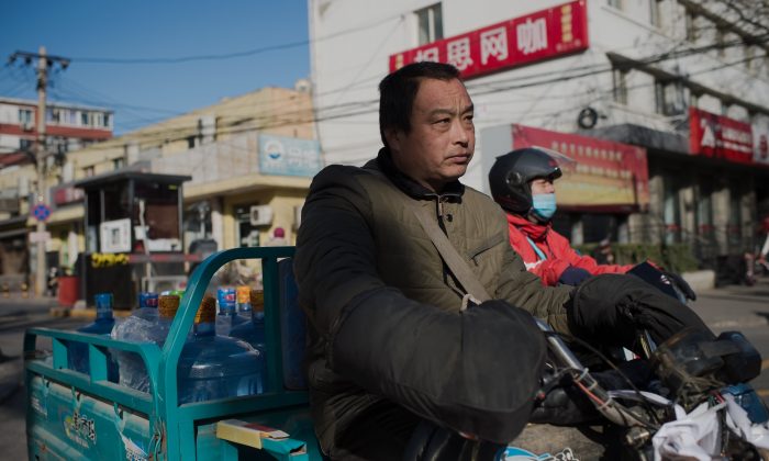 A water container delivery worker drives on a street in Beijing on Dec. 9, 2016.  Economist Ma Guangyuan says that China needs to develop genuine property rights to enhance economic growth. (Nicolas Asfouri/AFP/Getty Images)