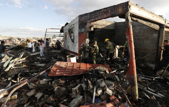 Firefighters and rescue workers comb through ashes and rubble at the open-air San Pablito fireworks market, in Tultepec, outskirts of Mexico City, Mexico on Dec. 20, 2016. An explosion ripped through Mexico's best-known fireworks market on the northern outskirts of the capital Tuesday, injuring scores and killing dozens, according to Mexican Federal Police. (AP Photo/Eduardo Verdugo)