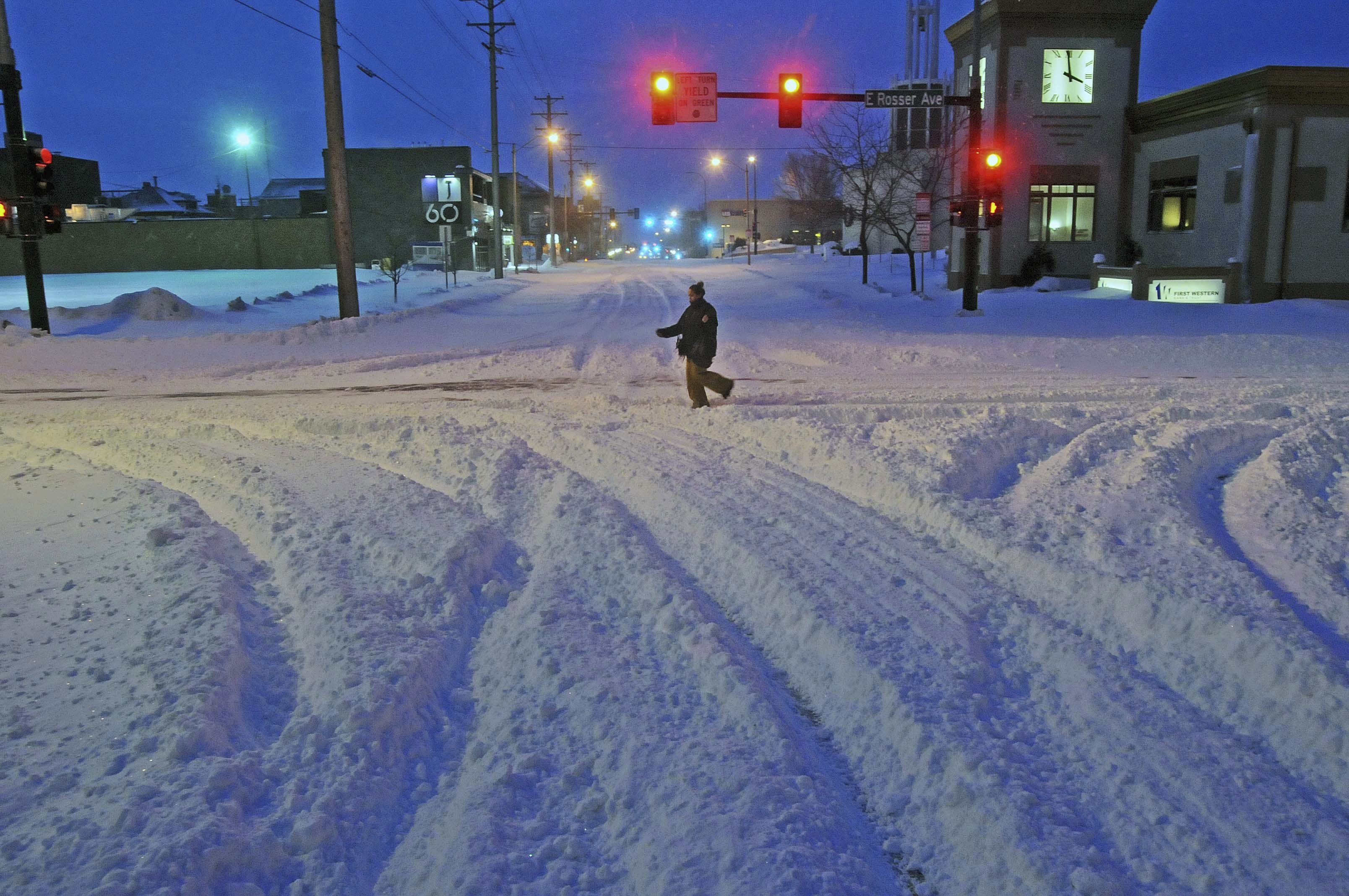 Madori Griffin, who says her car was snowed in, makes her way through an intersection while walking to work in the intensive care unit of Sanford Hospital in Bismarck, N.D., on, Dec. 26, 2016. (Tom Stromme/The Bismarck Tribune via AP)