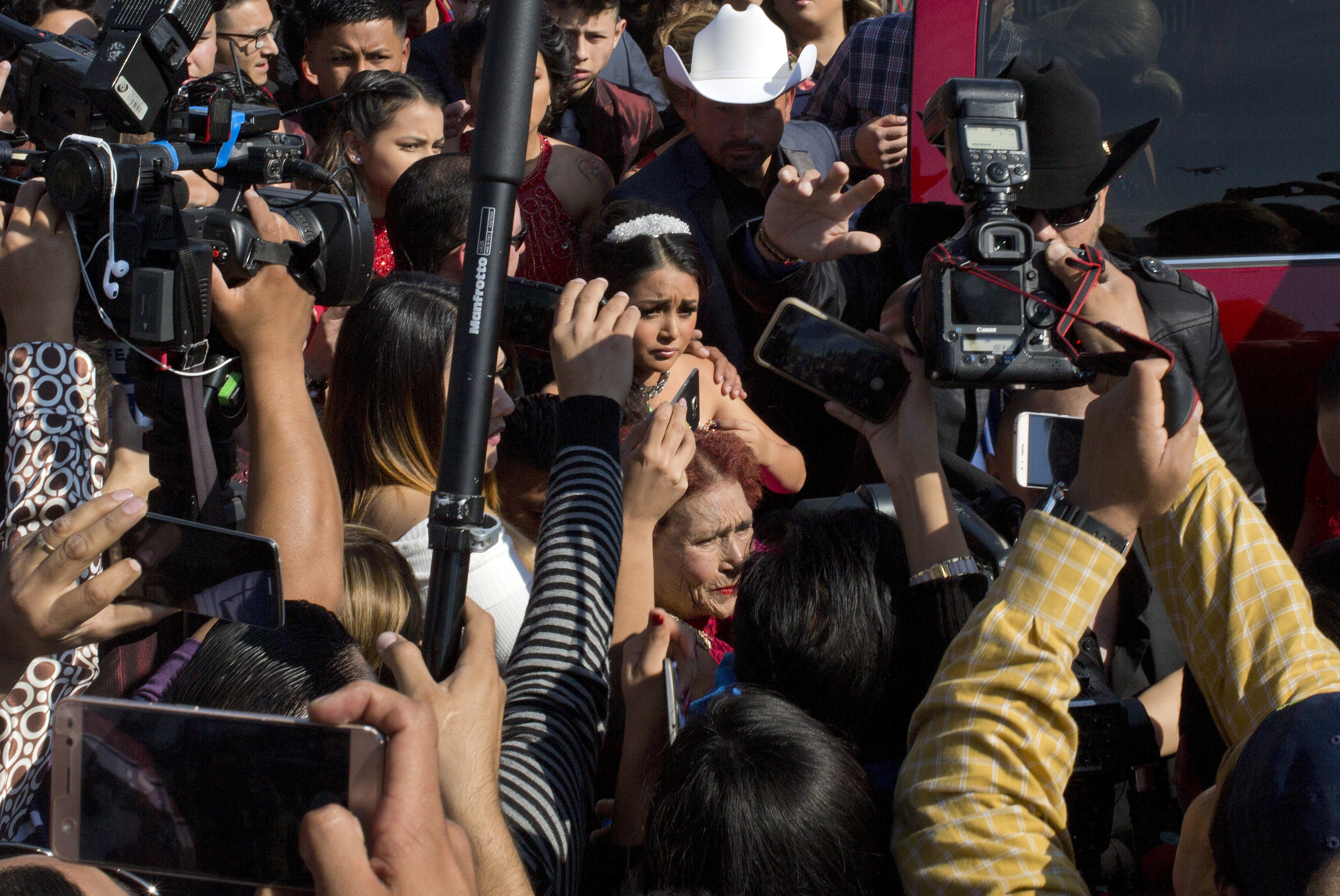 Rubi Ibarra arrives at the site of a Mass that is part of her down-home 15th birthday party, surrounded by a horde of journalists, in the village of La Joya, San Luis Potosi State, Mexico on Dec. 26, 2016. (AP Photo/Enric Marti)