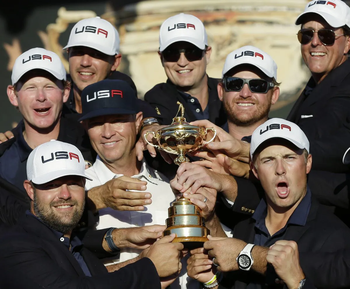 US Ryder Cup captain Davis Love III is surrounded by his victorious players as they pose for a picture during the closing ceremony of the Ryder Cup tournament at Hazeltine National Golf Club. (AP Photo/David J. Phillip)