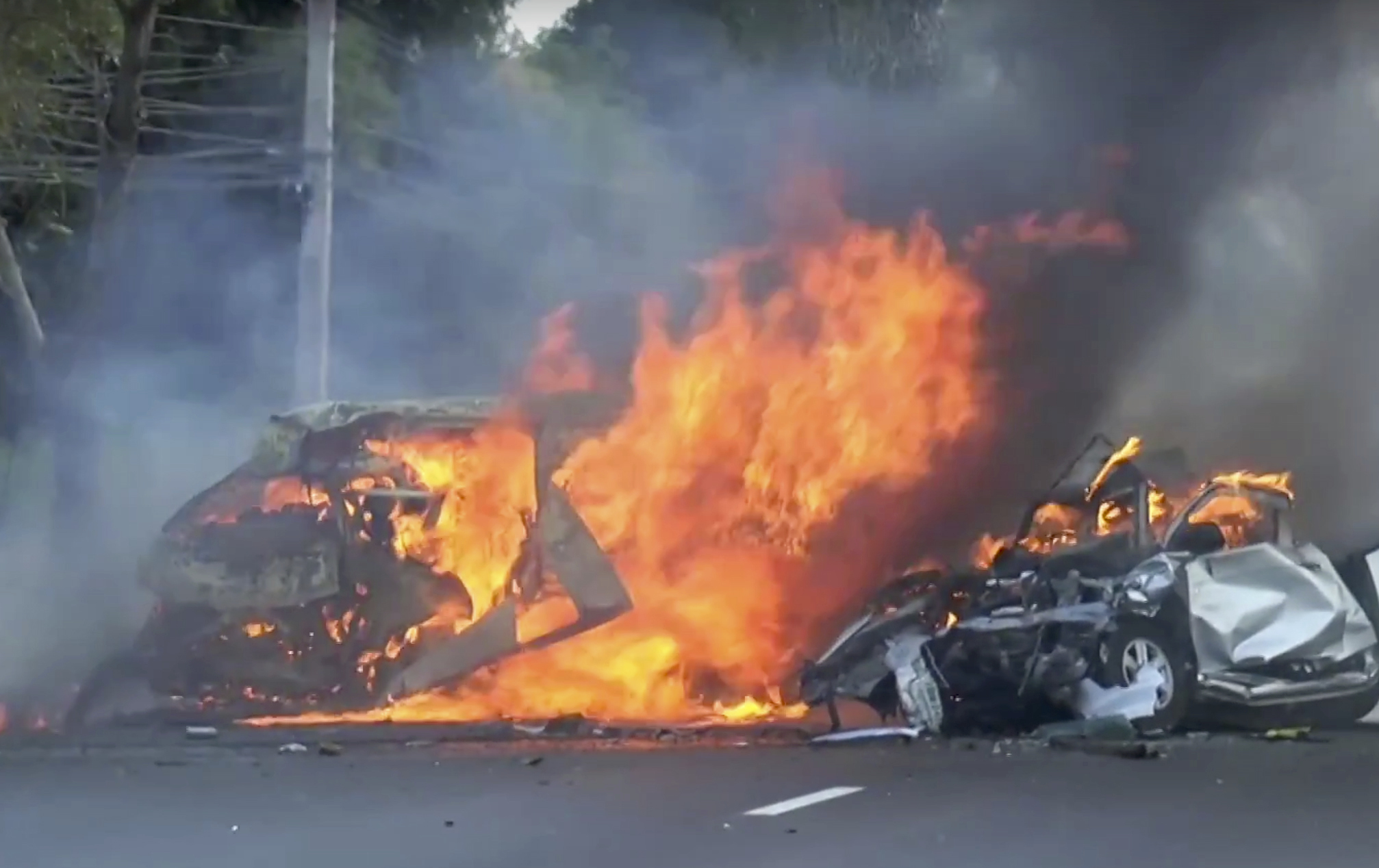 In this image made from video two vehicles burn after they collided on a highway east of Bangkok, Thailand on Jan. 2, 2017. (Matichon TV via AP)