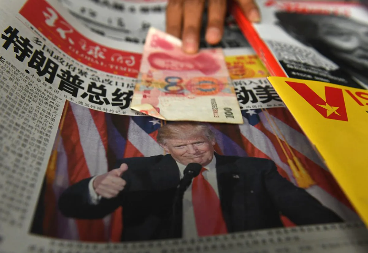 A 100 yuan note is placed above a newspaper featuring a photo of US president-elect Donald Trump at a news stand in Beijing on Nov. 10, 2016. (Greg Baker/AFP/Getty Images)