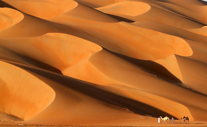 Emirati men walk with their camels across the Liwa Desert, some 150 miles west of Abu Dhabi, United Arab Emirates, during the Liwa Moreeb Dune festival on Jan. 6, 2017. The festival includes a variety of races such as of cars, bikes, falcons, camels, and horses, and other activities aimed at promoting the country's folklore. (Karim Sahib/AFP/Getty Images)
