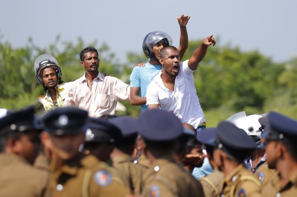 Sri Lankan villagers shout slogans during a protest in Mirijjawila village in Ambalantota, Sri Lanka, Saturday, Jan. 7, 2017. Sri Lankan police used water cannons to try to break up violent clashes Saturday between government supporters and villagers marching against what they say is a plan to take over private land for an industrial zone in which China will have a major stake. The government has signed a framework agreement for a 99-year lease of the Hambantota port with a company in which China will have 80-percent ownership. Officials also plan to set up the nearby industrial zone where Chinese companies will be invited to set up factories. (AP Photo/Eranga Jayawardena)