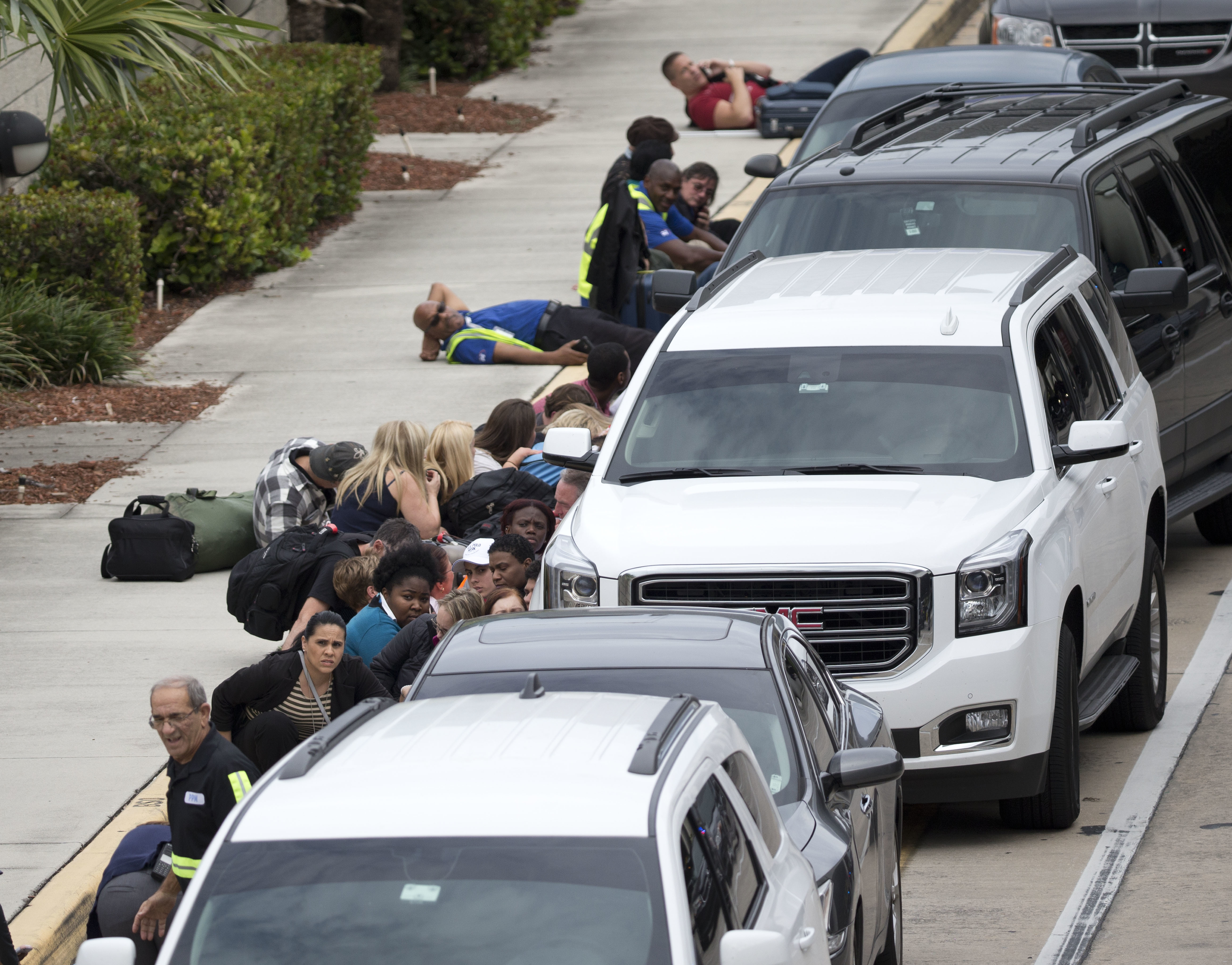 People take cover outside Fort Lauderdale–Hollywood International Airport in Fort Lauderdale, Fla., on Jan. 6, 2017. (AP Photo/Wilfredo Lee)