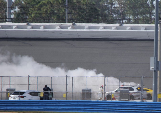 Marcel Fässler (white fire suit, helmet) watches the #4 Corvette Racing C7.R burn during Sunday morning's session of the IMSA WeatherTech Roar Before the Rolex 24 at Daytona International Speedway, Jan. 8, 2017.