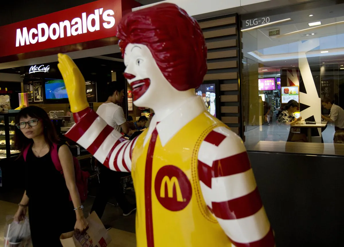 A customer walks past a statue of Ronald McDonald on display outside a McDonald's restaurant in Beijing on July 31, 2014. Fast food giant McDonald's said in a statement Monday, Jan. 9, 2017 it is selling a controlling stake in its China business to a group of investors led by state-owned Chinese conglomerate Citic in a deal worth up to $2.1 billion. (AP Photo/Andy Wong, File)