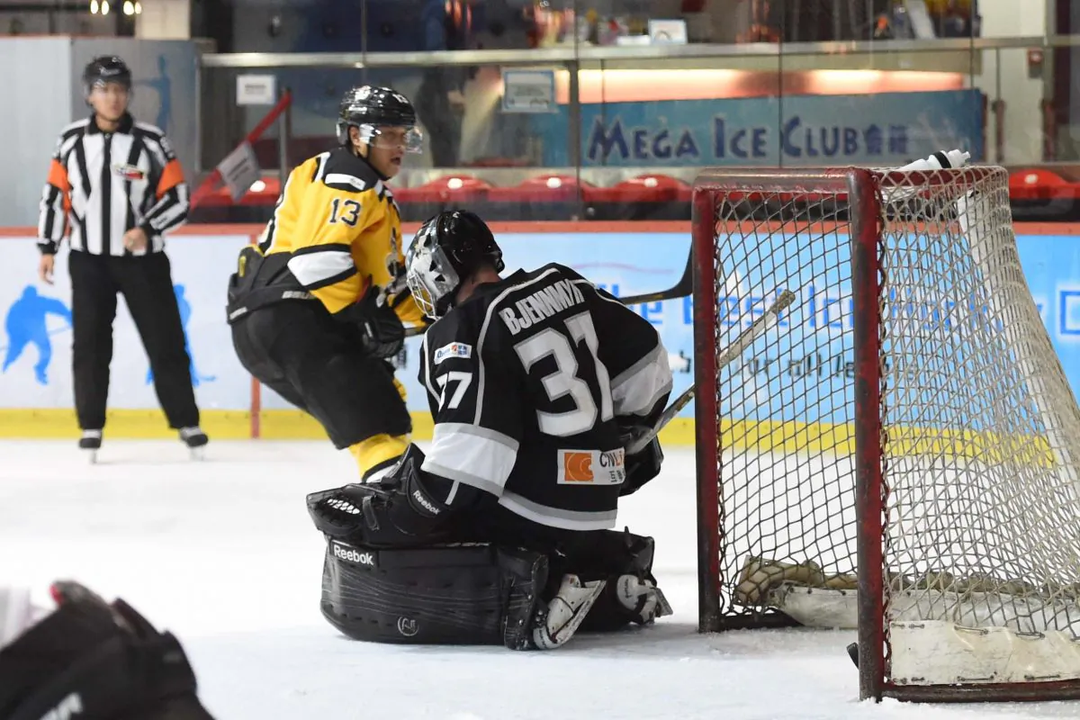 Craig Roessel of Hong Kong Tycoon slots home against South China Sharks' goalie Jimmy Bjennmyr in their CIHL League match at Mega Ice on Jan 5, 2017. (Bill Cox/Epoch Times)