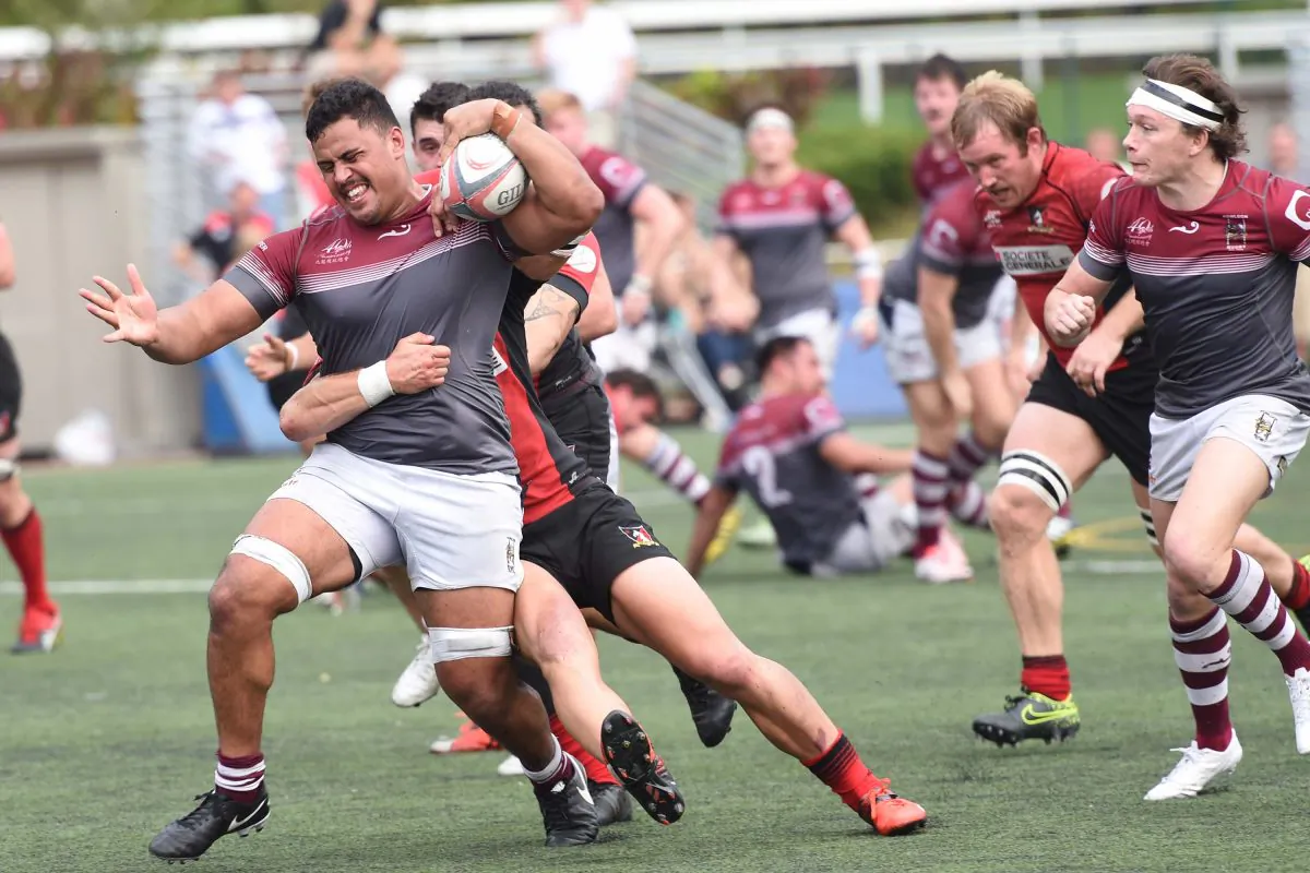 Kowloon’s No 8 Turoa Stephens forces his way forward under the restraint of Valley defenders during Kowloon’s 27-13 victory at Happy Valley on Saturday Jan 7. (Bill Cox/Epoch Times)