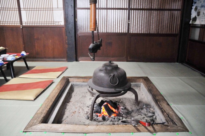 Figure 2 An irori with a jizaikagi (自在鉤), which is a hook consisting of an iron rod within a bamboo tube, and a fish-shaped yokogi (橫木). (Sun Mingguo/Epoch Times)