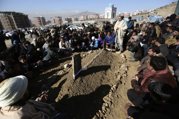 Villagers pray in front of the grave of a victim of Tuesday's two bombings in Kabul, Afghanistan, Wednesday, Jan. 11, 2017. The Taliban claimed attacks earlier on Tuesday in Kabul that killed at least 38 people and wounded dozens. (AP Photo/Rahmat Gul)
