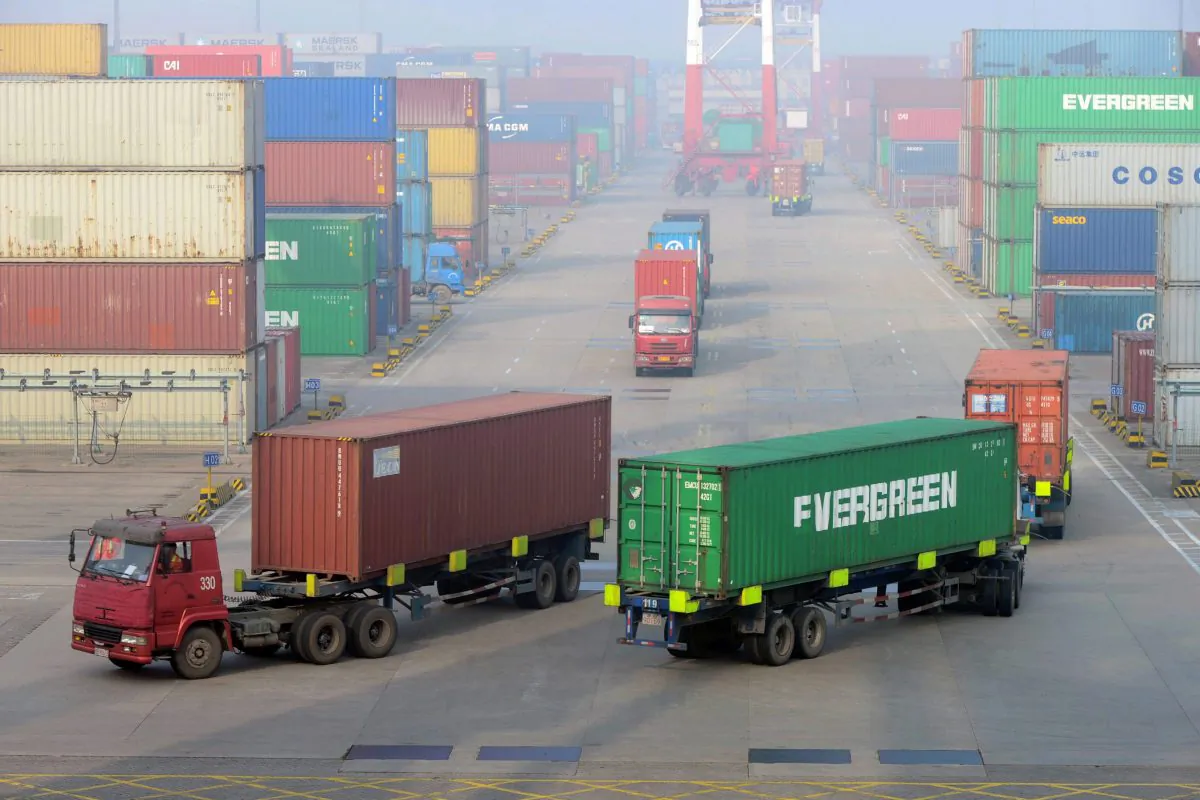 Cargo trucks drive through a container pool at a seaport in Qingdao in eastern China's Shandong province in this file photo. Canada aims to do more business with China amid a rising wave of protectionism. (Chinatopix via AP) 