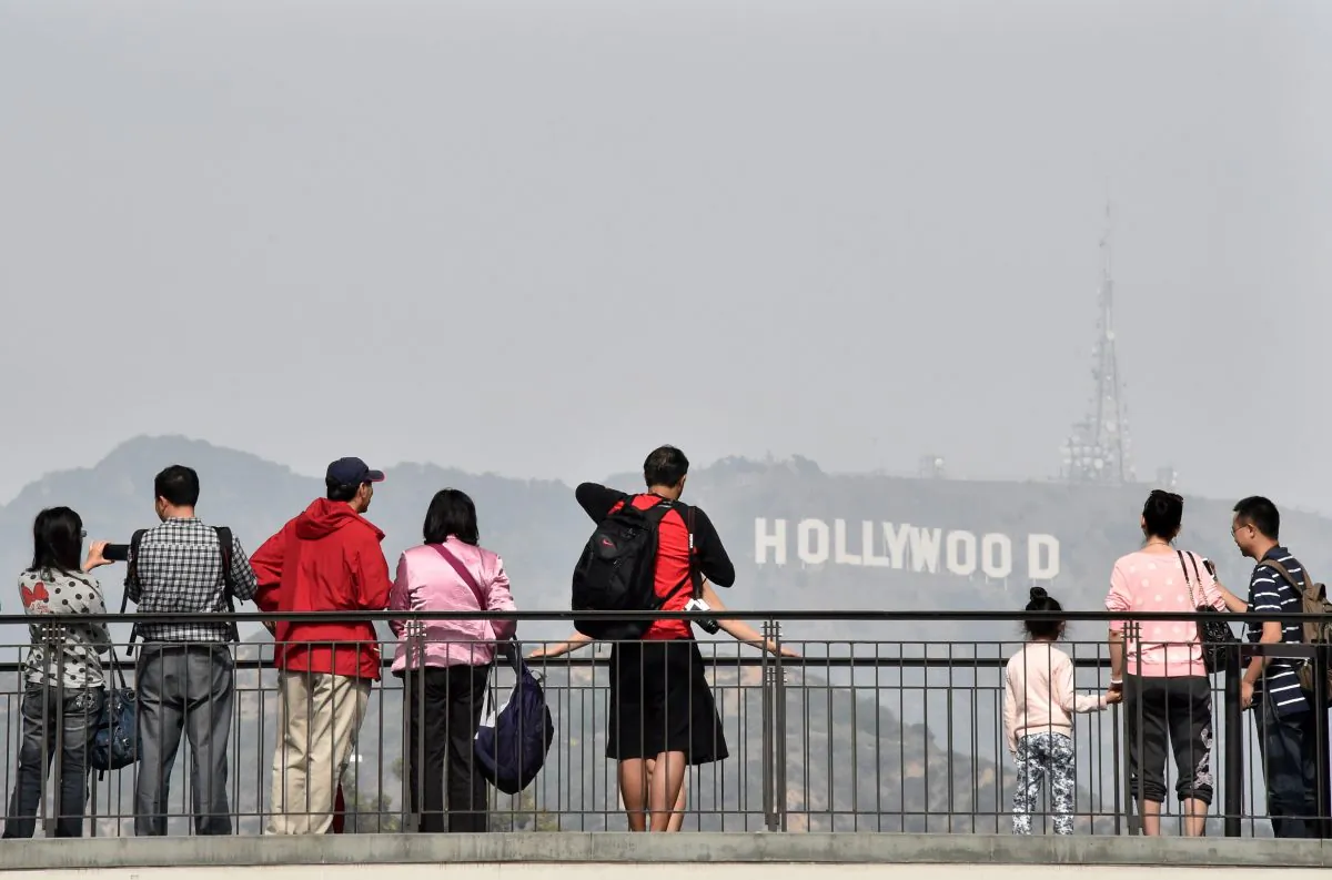 Tourists watch and photograph the Hollywood sign from a shopping mall terrace in Los Angeles, Calif. on Feb. 20, 2015. (MLADEN ANTONOV/AFP/Getty Images)