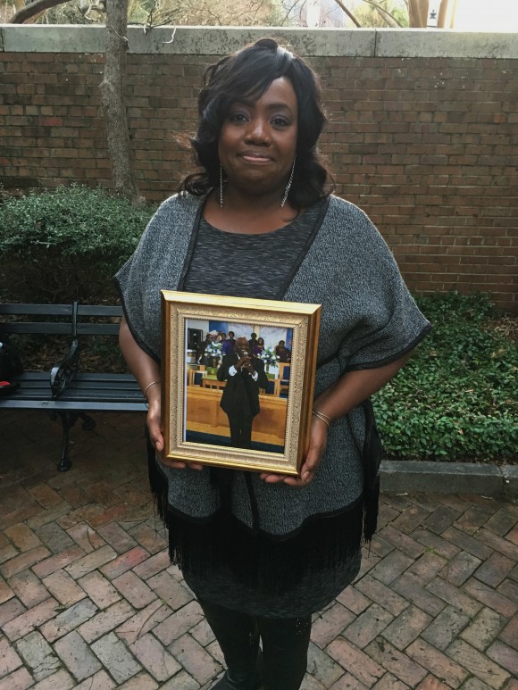 Rose Simmons, the daughter of Rev. Daniel Simmons, Sr., poses with a photograph of her father outside of U.S. District Court in Charleston, S.C., Wednesday, Jan. 11, 2017, hours after Judge Richard Gergel formally confirmed jurors on Tuesday sentenced Dylann Roof to death. Simmons said Roof killed her father and eight others at Emanuel AME Church on June 17, 2015. (AP Photo/Alex Sanz)