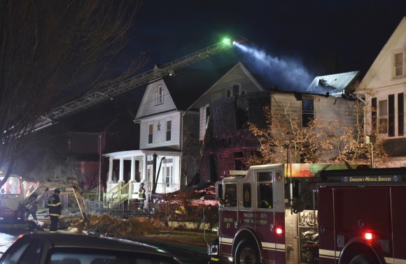 Baltimore City firefighters remain on the scene early Thursday, Jan. 12, 2017, after a fire on Springwood Avenue in northeast Baltimore. Several children and an adult were taken to an area hospital. Six children are still missing. (Jerry Jackson/The Baltimore Sun via AP)