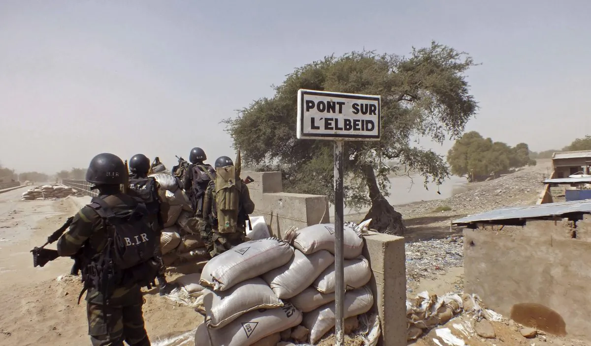 Cameroon soldiers stand guard at a lookout post as they take part in operations against the Islamic extremists group Boko Haram, their guard post is on Elbeid bridge, left rear, that separates northern Cameroon form Nigeria's Borno state near the village of Fotokol, Cameroon. (Edwin Kindzeka Moki/AP Photo)