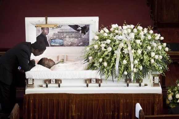 In this file photo, Franclot Graham leans over his son, Ramarley Graham, in his casket before funeral services in the Bronx borough of New York, on Feb. 18, 2012. (AP Photo/John Minchillo)
