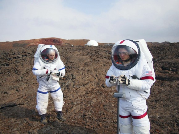 In this photo provided by the University of Hawaii, Lucie Poulet, right, uses a geotechnical tool while Annie Caraccio records the data during a previous study outside the domed structure that will house six researchers for eight months in an environment meant to simulate an expedition to Mars, on Mauna Loa on the Big Island of Hawaii, on May 23, 2014. (Ross Lockwood/University of Hawaii via AP)
