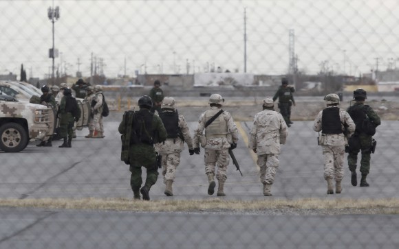 Soldiers walk at the airport after the extradition of drug lord Joaquin "El Chapo" Guzman in Ciudad Juarez, Mexico, Thursday, Jan. 19, 2017. Mexico's Foreign Relations Department announced Guzman was handed over to U.S. authorities for transportation to the U.S. on Thursday, the last day of President Barack Obama's administration and a day before Donald Trump is to be inaugurated. (AP Photo/Christian Torres)