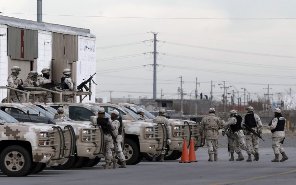 Soldiers wait at the airport after the extradition of drug lord Joaquin "El Chapo" Guzman in Ciudad Juarez, Mexico on Jan. 19, 2017. Mexico's Foreign Relations Department announced Guzman was handed over to U.S. authorities for transportation to the U.S. on Thursday, the last day of President Barack Obama's administration and a day before Donald Trump is to be inaugurated. (AP Photo/Christian Torres)