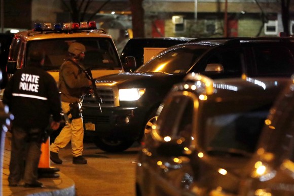 An armed officer stands guard as a vehicle carrying Mexican drug kingpin Joaquin "El Chapo" Guzman arrives at the Metropolitan Correctional Center in New York, Thursday, Jan. 19, 2017. The infamous drug kingpin who twice escaped from maximum-security prisons in Mexico was extradited at the request of the U.S. to face drug trafficking and other charges, and landed in New York late Thursday, a federal law enforcement official said. (AP Photo/Julio Cortez)
