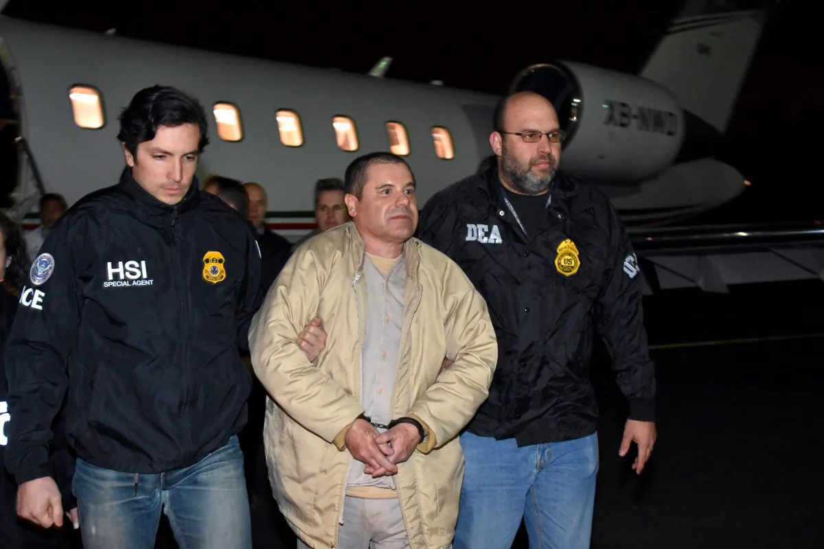 Authorities escort Joaquin "El Chapo" Guzman (C) from a plane to a waiting caravan of SUVs at Long Island MacArthur Airport in Ronkonkoma, N.Y., on Jan. 19, 2017. (U.S. law enforcement via AP)
