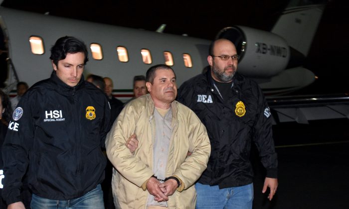 Authorities escort Joaquin "El Chapo" Guzman (C) from a plane to a waiting caravan of SUVs at Long Island MacArthur Airport in Ronkonkoma, N.Y., on Jan. 19, 2017. (U.S. law enforcement via AP)
