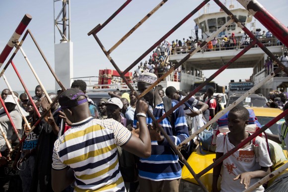 A ferry bringing back people who fled arrives at the port in Banjul, Gambia, as it reopens Saturday Jan. 21, 2017. life slowly returns to the Gambian capital as Gambia's defeated leader Yahya Jammeh announced early Saturday he has decided to relinquish power, after hours of last-ditch talks with regional leaders and the threat by a regional military force to make him leave. (AP Photo/Jerome Delay)