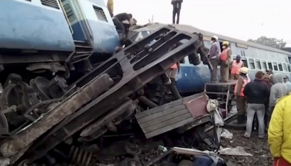 Rescuers stand around coaches of a derailed passenger train in Kuneru, Andhra Pradesh, southern India, on Jan. 22, 2017. (KK Production via AP)