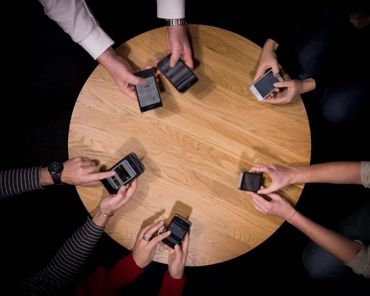 People hold their smartphones around a conference table in France on Jan. 5, 2016. Effectively partnering public relations with digital advertising could generate positive results for small businesses.
(Lionel Bonaventure/AFP/Getty Images)