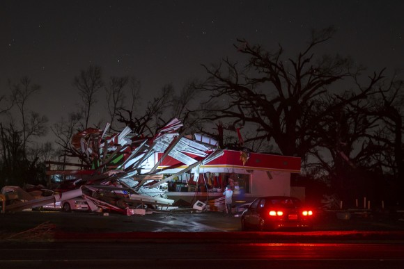 People stop to take a photo of a gas station damaged by an apparent tornado, Sunday, Jan. 22, 2017, in Albany, Ga. Nathan Deal declared a state of emergency in several counties, including Cook, that have suffered deaths, injuries and severe damage from weekend storms. (AP Photo/Branden Camp)