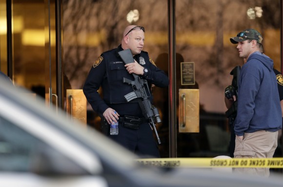San Antonio police stand guard at an exit to the Rolling Oaks Mall after a deadly shooting Sunday, Jan. 22, 2017, in San Antonio. Authorities say several were injured after a robbery at the shopping mall. (AP Photo/Eric Gay)
