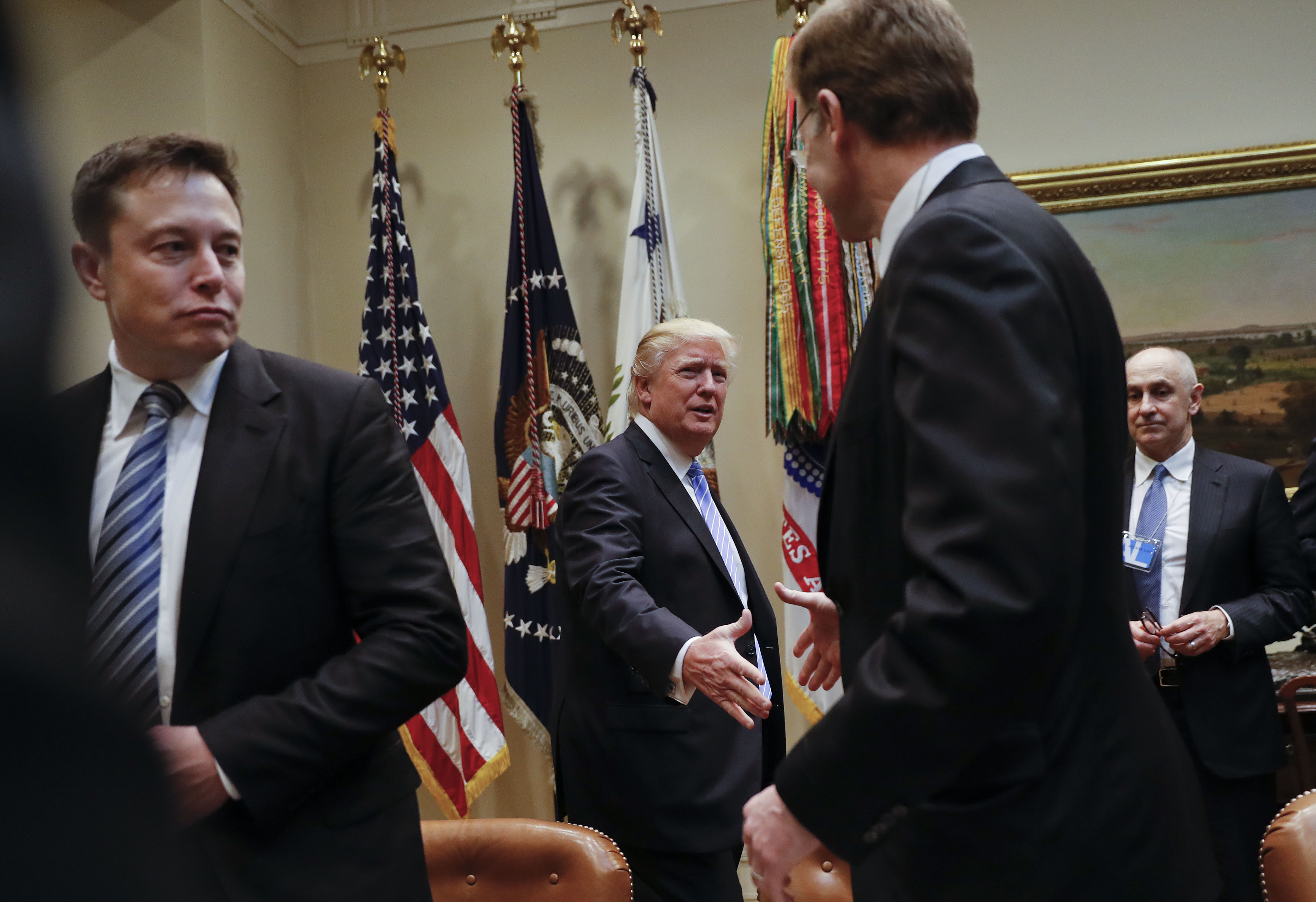President Donald Trump greets Wendell P. Weeks (R) Chief Executive Officer of Corning, as he host breakfast with business leaders in the Roosevelt Room of the White House in Washington on Jan. 23, 2017. (AP Photo/Pablo Martinez Monsivais)