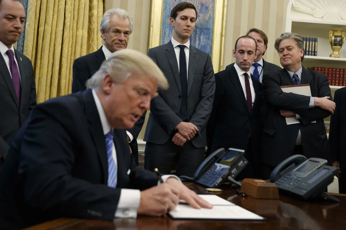 Then-White House Chief of Staff Reince Priebus, then-National Trade Council adviser Peter Navarro, then- Senior Adviser Jared Kushner, then- policy adviser Stephen Miller, and then-chief strategist Steve Bannon watch as former President Donald Trump signs an executive order in the Oval Office of the White House in Washington on Jan. 23, 2017. (AP Photo/Evan Vucci)