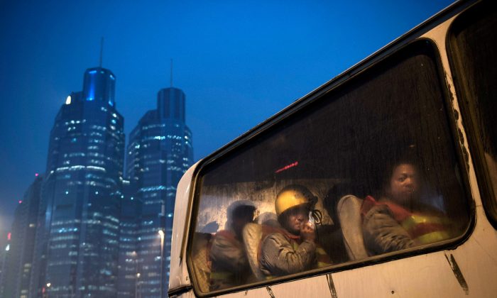 Chinese migrant workers wait in a bus as they leave after their shift at a construction site on Dec. 9, 2014 in Beijing, China. It is estimated that there are more than 40 million construction laborers in China, many of whom come from smaller centers to the country's larger cities to find work. (Kevin Frayer/Getty Images)