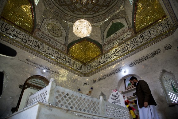 Amir Sajjad, brother of Mumtaz Qadri who was hanged for killing a politician, arranges flowers at the shrine of his brother in Barakhao, Pakistan on Jan. 11, 2017. (AP Photo/B.K. Bangash)
