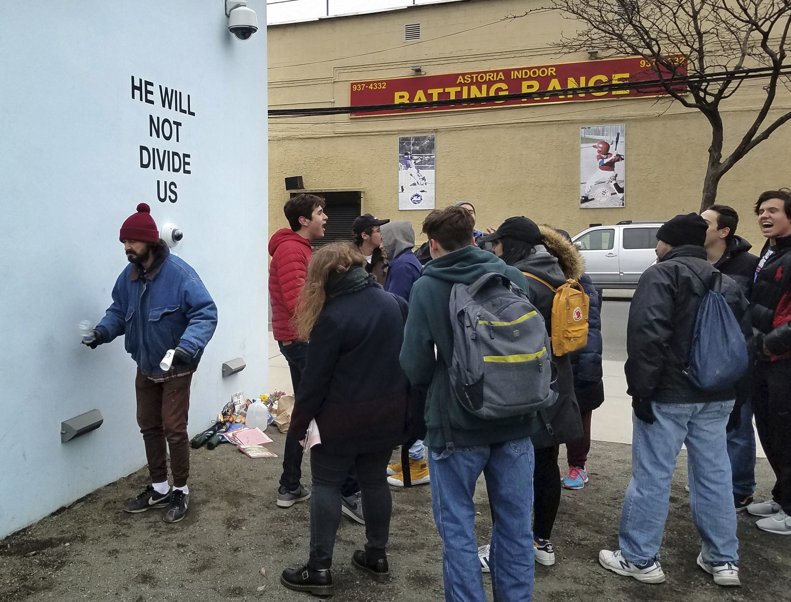 Actor Shia LeBeouf (L) stands in front of a live-steam camera outside of the the Museum of the Moving Image as members of the public join LeBeouf in chanting the words "He will Not Divide Us" in the Queens borough of New York. (AP Photo/Deepti Hajela)